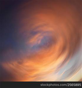 Spiral orange clouds in sky with sunset.