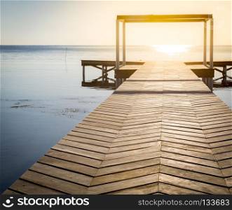 Spiritual Background Of Wooden Boardwalk. Spiritual background of sunrise at the end of a wooden boardwalk over calm water with copy space