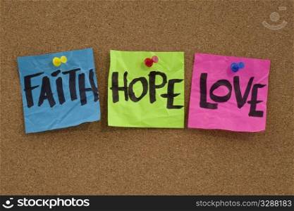 spiritual reminder or methaphysical concept - faith, hope and love handwritten on colorful notes and posted on cork bulletin board