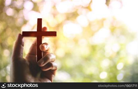 Spirituality and Religion Concept, Person Holding Christian Cross to Making Pray Outdoors. Believe and Faith for Christian People
