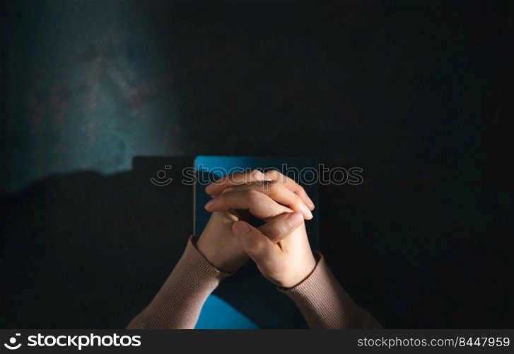 Spirituality, Religion and Hope Concept. Person Praying by Holy Bible on Desk. Symbol of Humility, Supplication,Believe and Faith for Christian People. Top View