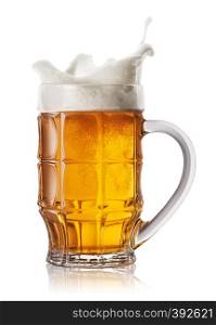 Splash in beer mug isolated on white background. Splash foam in faceted mug of light beer. Splash in beer mug