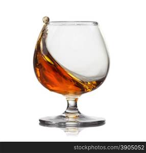 Splash of cognac in glass isolated on white background