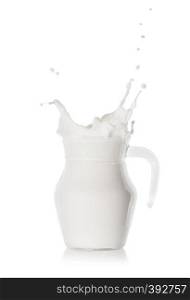 Splash of fresh white milk in glass modern jug isolated on white background. Splash of fresh white milk in a glass modern jug