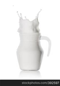 Splash of milk in a glass jug isolated on a white background. Splash of milk in glass jug