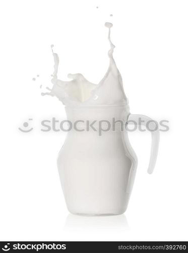 Splash of milk in a glass jug isolated on white background. Splash of milk in a glass jug