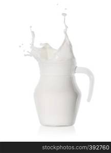 Splash of milk in a glass jug isolated on white background. Splash of milk in a glass jug