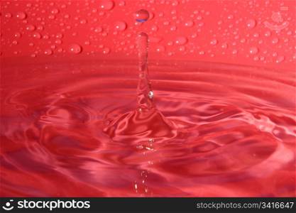 splashing water droplets on red background