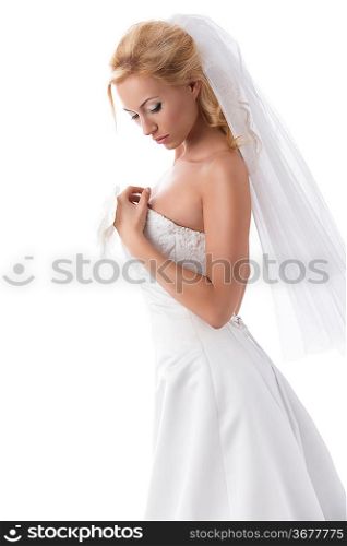 splendid bride with blonde hair in sensual pose wearing elegant dress, veil and floral decoration on hand.