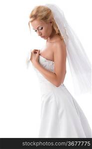 splendid bride with blonde hair in sensual pose wearing elegant dress, veil and floral decoration on hand.