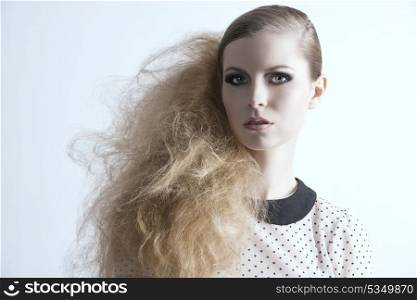 splendid fashion blonde lady with rock creative hair-style, dark make-up and pois shirt looking in camera