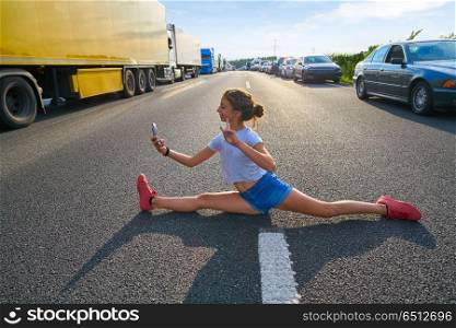 Split legs girl selfie photo in a traffic jam road having fun. Split legs girl selfie photo in a traffic jam road