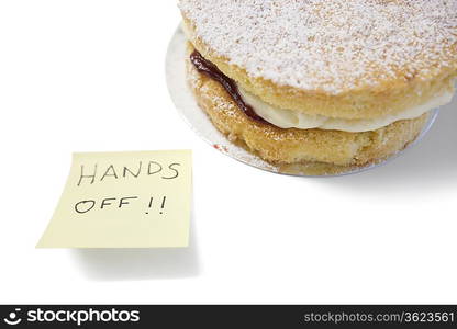 Sponge cake with &acute;hands off&acute; sign on sticky notepaper