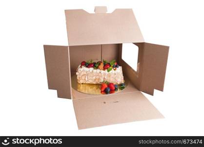sponge cake with berries in a cardboard box isolated