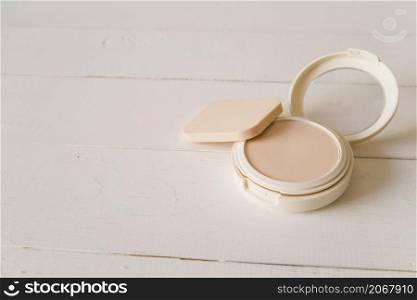 sponge with compact face powder beige backdrop
