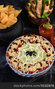 Spooky Halloween Seven Layer Taco Dip: Turn a classic appetizer into a Halloween with of black olive spider .