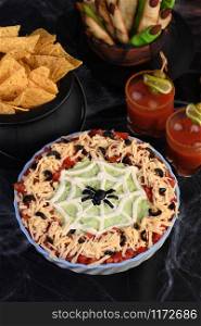 Spooky Halloween Seven Layer Taco Dip Turn a classic appetizer into a Halloween favorite with just a little sour cream artistry and a of black olive spiders.