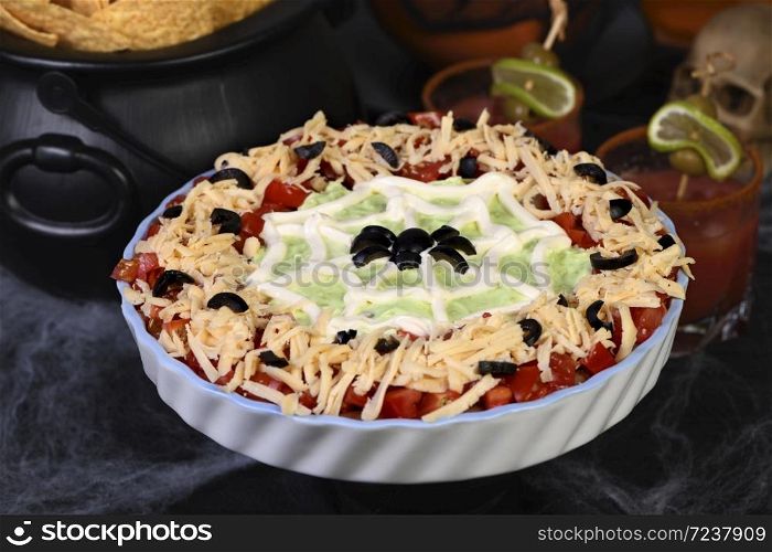 Spooky Halloween Seven Layer Taco Dip Turn a classic appetizer into a Halloween favorite with just a little sour cream artistry and a of black olive spiders.