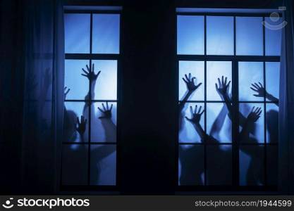 Spooky zombie hands on a window