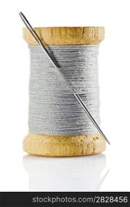 spool with gray thread and nidle