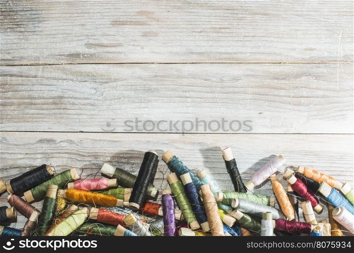 Spools of thread on white wood background