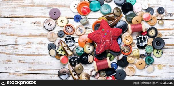 Spools of threads and buttons on wooden table.Scissor, sewing buttons and thread. Buttons and threads with needle
