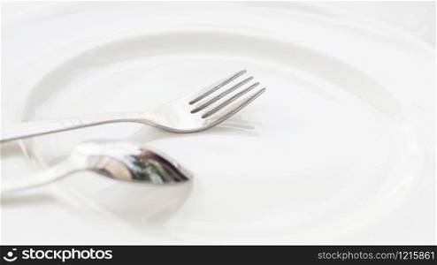 spoon and fork on a white plate.