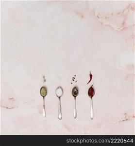 spoon filled with spices arranged row old pink backdrop