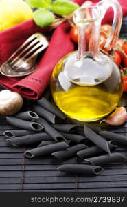 Spoon, fork, napkin and pasta ingredients (Penne, olive oil, basil, mushrooms, tomato, lemon)