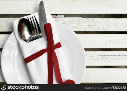 spoon knife and fork in napkin on white plate