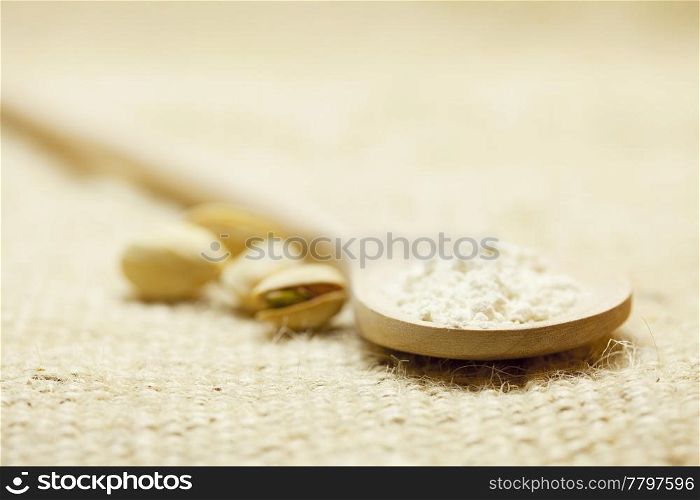 spoon of flour and Pistachios on linen fabric