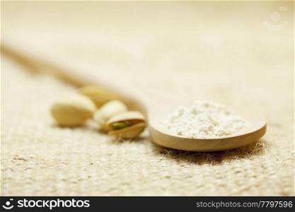 spoon of flour and Pistachios on linen fabric