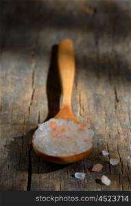 Spoon of pink himalayan salt on wooden table
