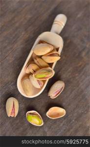 spoon of raw pistachio nuts on a old wooden background
