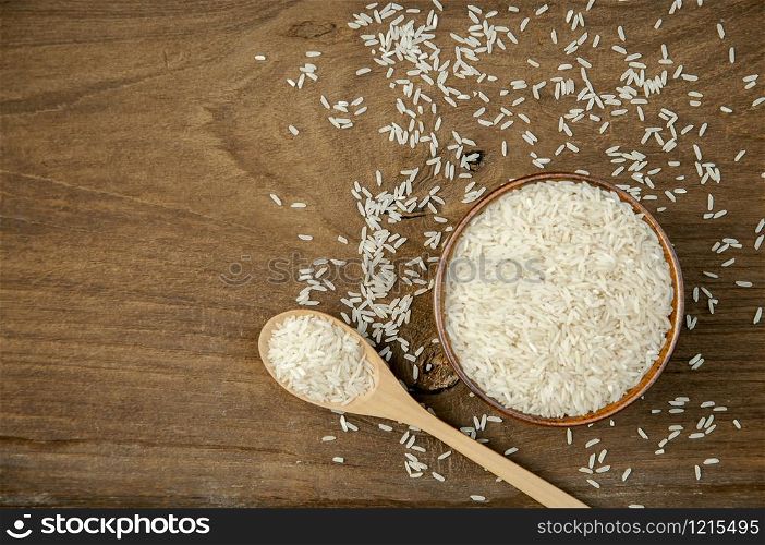 Spoon rice bowl on brown wood floor.