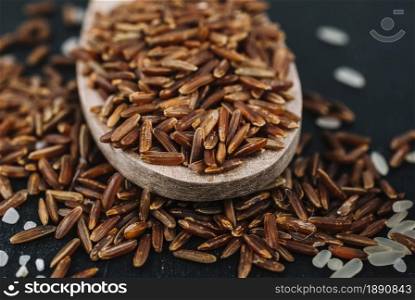spoon with brown rice spilled grains. Resolution and high quality beautiful photo. spoon with brown rice spilled grains. High quality and resolution beautiful photo concept