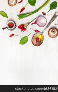 Spoon with oil and spices and various vegetarian ingredients for healthy eating on white wooden background, top view