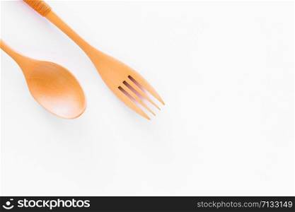 Spoons and forks made of wood split with a white background.