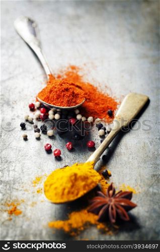 Spoons with spices on vintage background