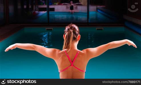 Sport active lifestyle. Sporty woman female swimmer muscular fit body preparing to jump into swimming pool back view