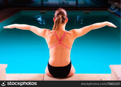 Sport active lifestyle. Sporty woman female swimmer muscular fit body preparing to jump into swimming pool back view