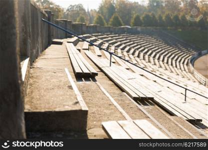 sport and architecture concept - close up of stands or rows of benches on stadium. close up of bleachers with benches on stadium
