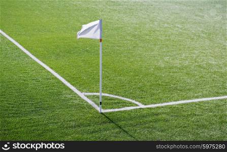 sport and game concept - close up of football field corner with flag marker. close up of football field corner with flag marker