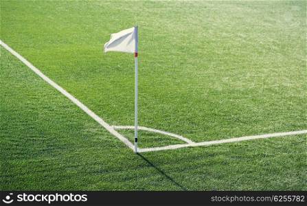 sport and game concept - close up of football field corner with flag marker. close up of football field corner with flag marker