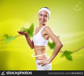 Sport and healthy food. Young pretty girl in sport wear with green apple