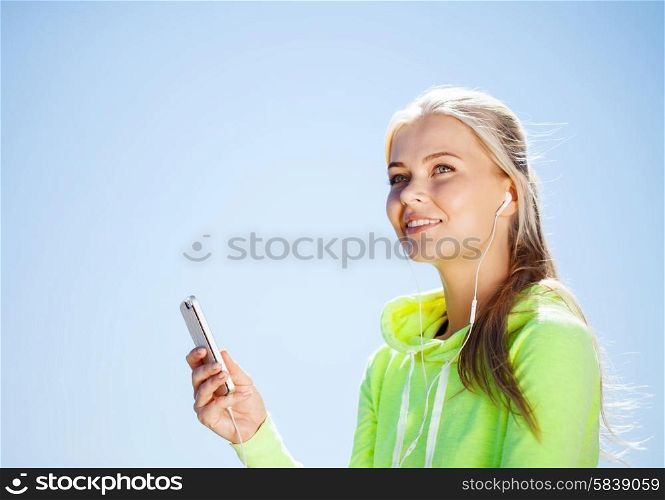 sport and lifestyle concept - woman doing sports and listening to music outdoors. woman listening to music outdoors