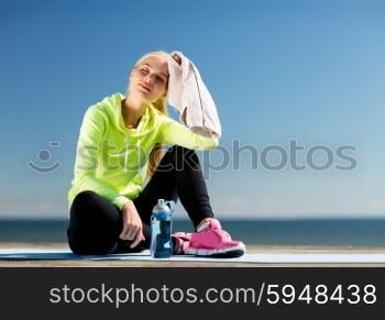 sport and lifestyle concept - woman resting after doing sports outdoors. woman resting after doing sports outdoors