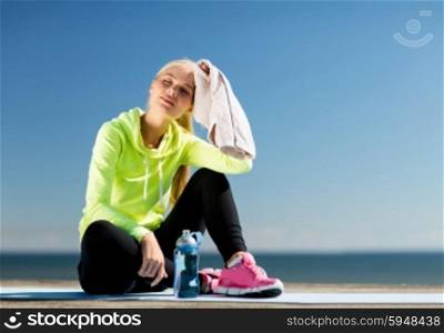 sport and lifestyle concept - woman resting after doing sports outdoors. woman resting after doing sports outdoors