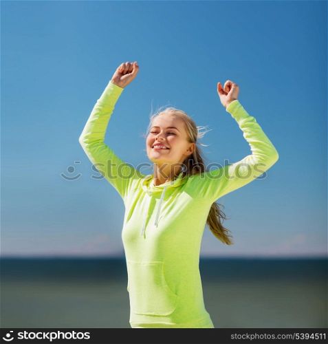 sport and lifestyle concept - woman runner celebrating victory