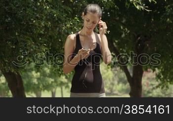 Sport and music, beautiful young woman with mp3 player listening to tunes and running in city park